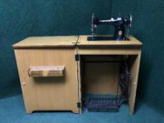 A mid 20th century Singer treadle machine in case