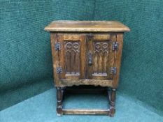 A carved oak bedside cabinet