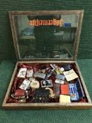 A display case of spoon, WWI medals, Kosovo medal, Dirk pin badges, military buttons, wrist watches,