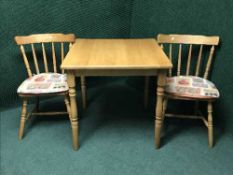 A square kitchen table and two chairs