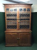 An antique pine leaded door school cupboard
