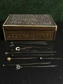 A carved trinket box containing a quantity of hat pins,