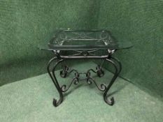 A glass topped wrought iron lamp table
