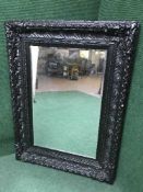 A large decorative black framed mirror