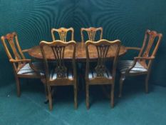 An inlaid yew wood twin pedestal dining table with a leaf and six dining chairs