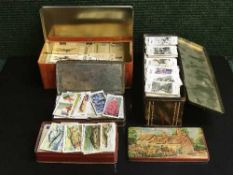 Four vintage tins containing Brooke Bond tea cards, Lions cards, Wills cigarette cards,