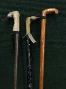 A pair of two deer hoof handled walking sticks and one other