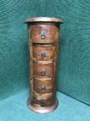 A cylindrical hardwood five drawer chest