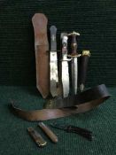 A basket of leather belts, pen knives, Tombstone OK Corral bowie knife,
