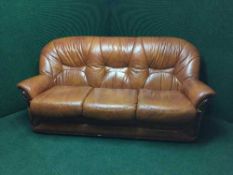 A tan leather three seater settee