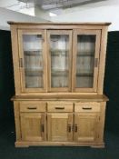 A contemporary light oak sliding door display cabinet
