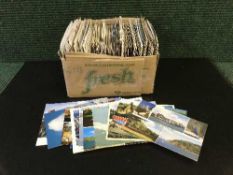 A black pottery Puma and a box of 20th century postcards