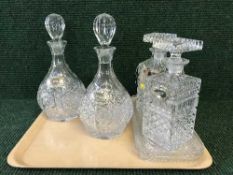 A tray of four decanters with labels and two trinket trays