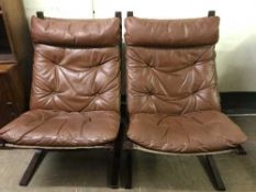 A pair of mid 20th century Danish brown button leather armchairs