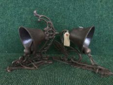 Two cast metal bells on wall brackets (2)