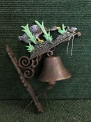 A cast metal wall bracket with bell - Duck
