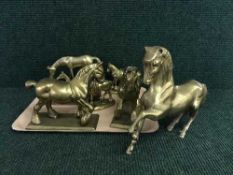 A tray of six heavy brass ornaments of horses