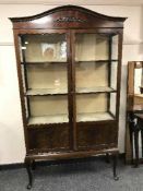 A glazed Edwardian mahogany display cabinet on pad feet
