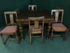 An early twentieth century oak pull out table together with six chairs