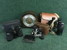 A box of oak Smiths mantel clock, pair of cased Ross of London binoculars,