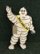 A cast metal plaque Michelin man