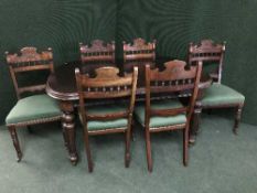 A Victorian mahogany wind out table with winder and leaf and six carved dining chairs
