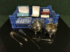 A basket of costume jewellery, silver tongs, button hook,
