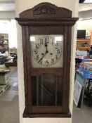 An early 20th century oak wall clock