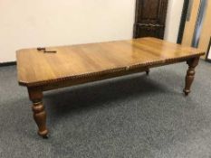 A Victorian oak extending dining table with leaf and handle