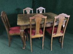 An early 20th century oak dining table and five single chairs