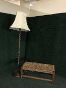 A large oak rush seated duet stool together with a barleytwist standard lamp with shade