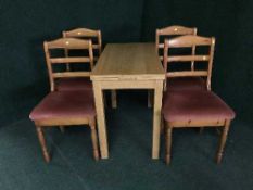 A contemporary oak narrow dining table and four pine chairs