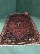 A Persian woolen Khamseh rug on red ground