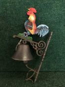A cast metal cockerel wall bracket with bell