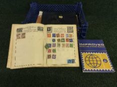 A basket of three stamp albums and loose stamp sheets
