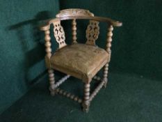 A heavily carved oak corner chair