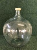 A glass carboy and two large pottery storage jars