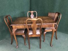 A walnut extending dining table with leaf and four chairs
