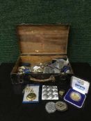 An old wooden box containing badges, collectables, coins,