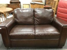 A brown leather two seater settee