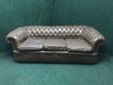 A three seater brown leather Chesterfield settee