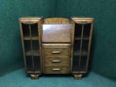 An oak glazed door bookcase with central bureau
