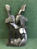 A carved abstract statue of a lady and man