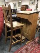 An early 20th century oak school desk with oak stepped high stool