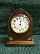 A mahogany mantel clock on brass bracket feet