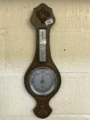 A carved oak aneroid barometer/thermometer