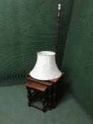 A nest of three oak tables and a standard lamp