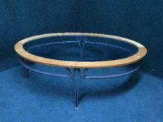 A teak and glass topped oval coffee table