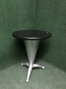 A circular coffee table on metal tripod base