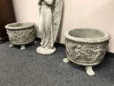 A pair of ornate cherub planters on paw feet
